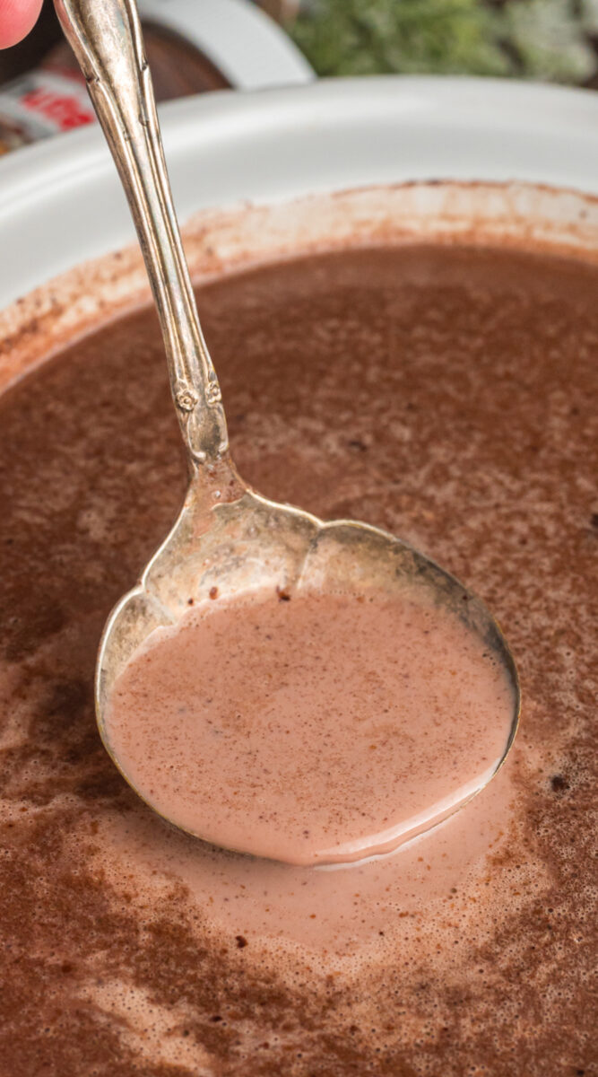 Hot chocolate on a ladle coming from a crockpot.