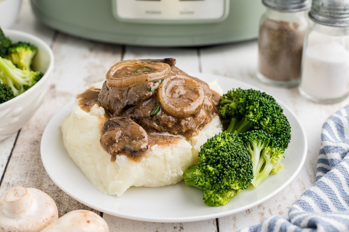 Plate of Salisbury steak over mashed potatoes.