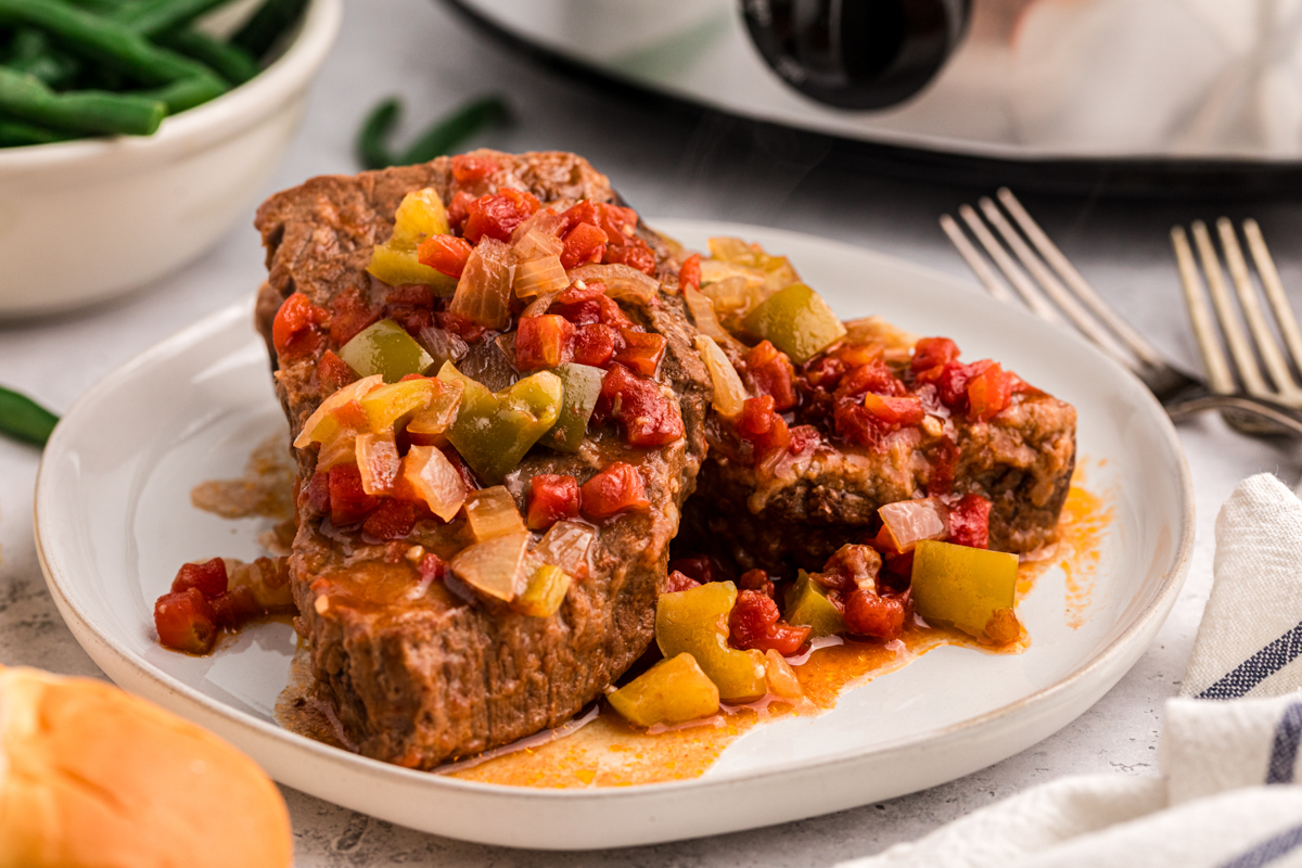 serving of slow cooker swiss steak on a white plate.