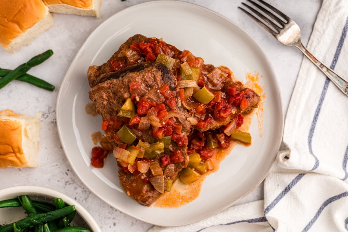 overhead of crockpot swiss steak on a white plate.