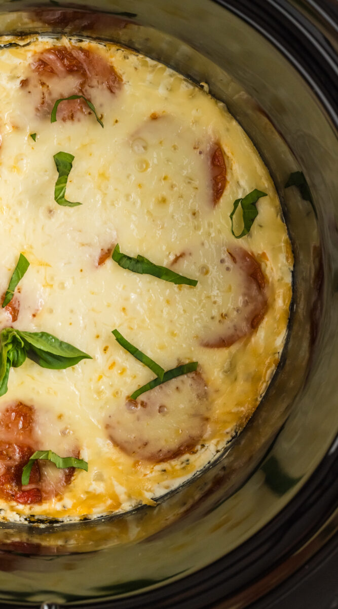 long image of white pizza dip in a slow cooker.