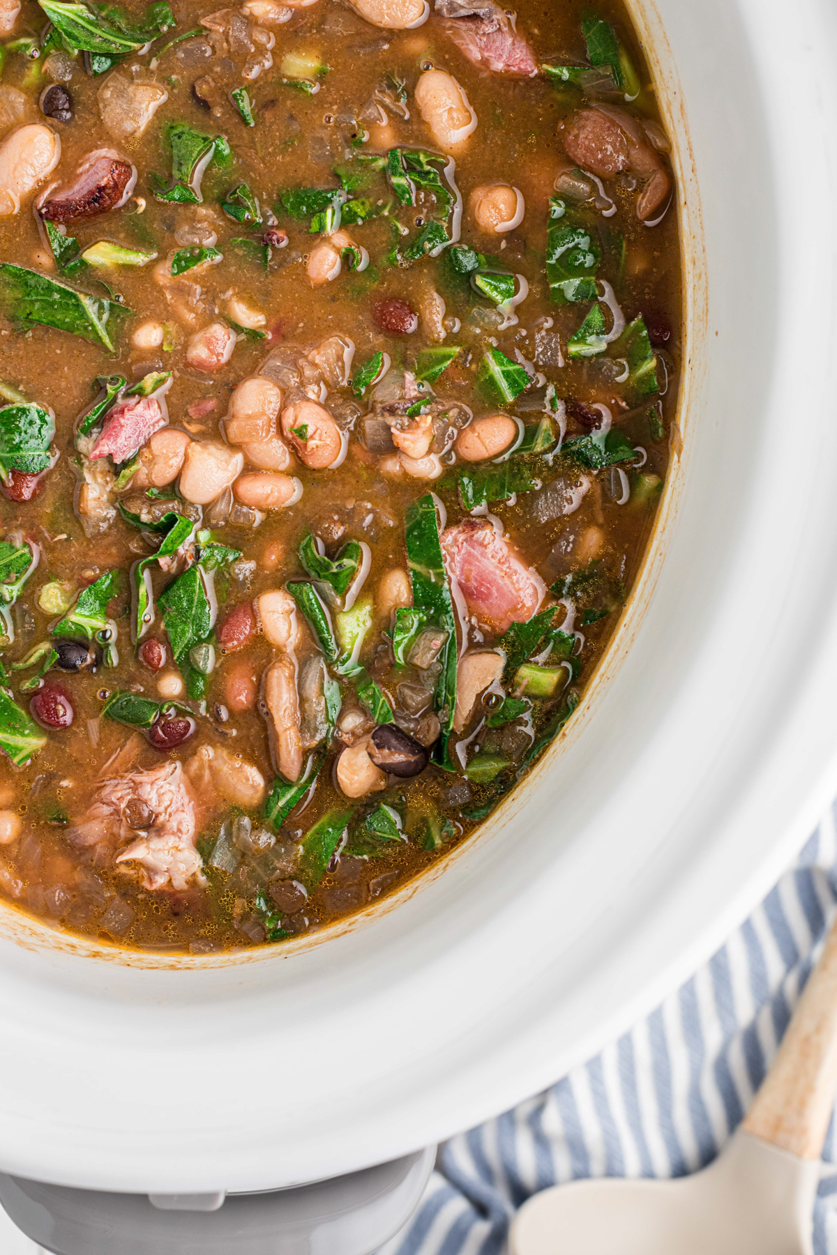 overhead shot of 15 Bean Soup with Ham and Collard Greens in a slow cooker.