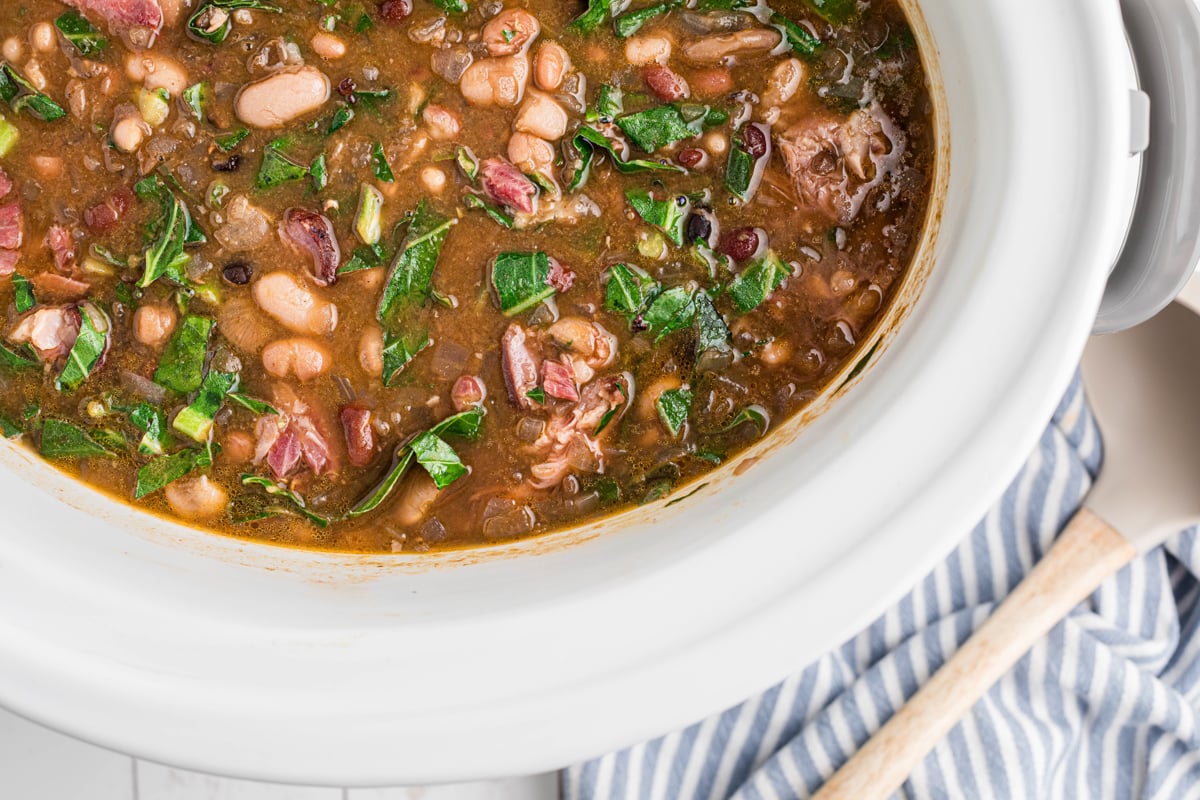 overhead of slow cooker 15 bean soup with ham and collard greens.