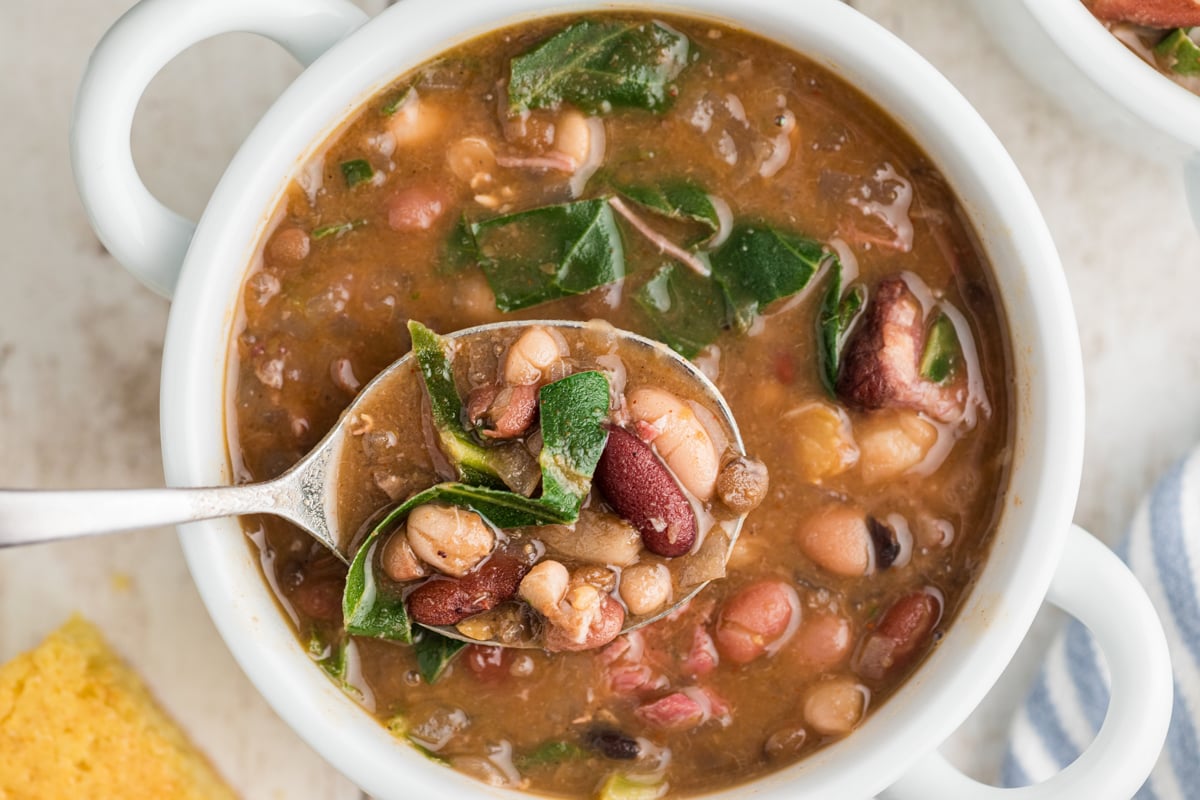 overhead of slow cooker 15 bean soup with ham and collard greens in a bowl.