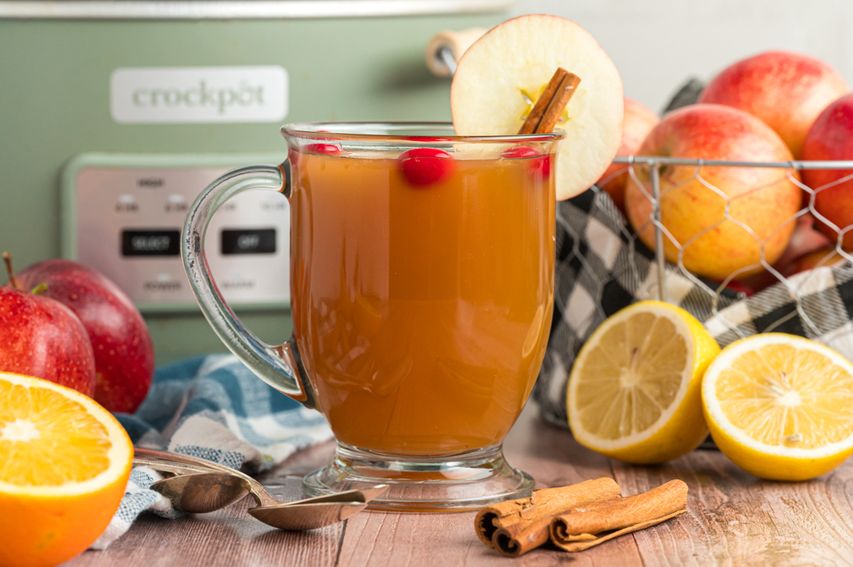 front view of slow cooker apple cider in a clear mug.