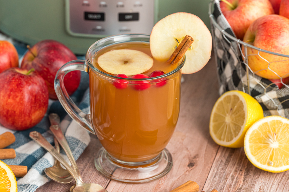 overhead of slow cooker apple cider in a clear mug.