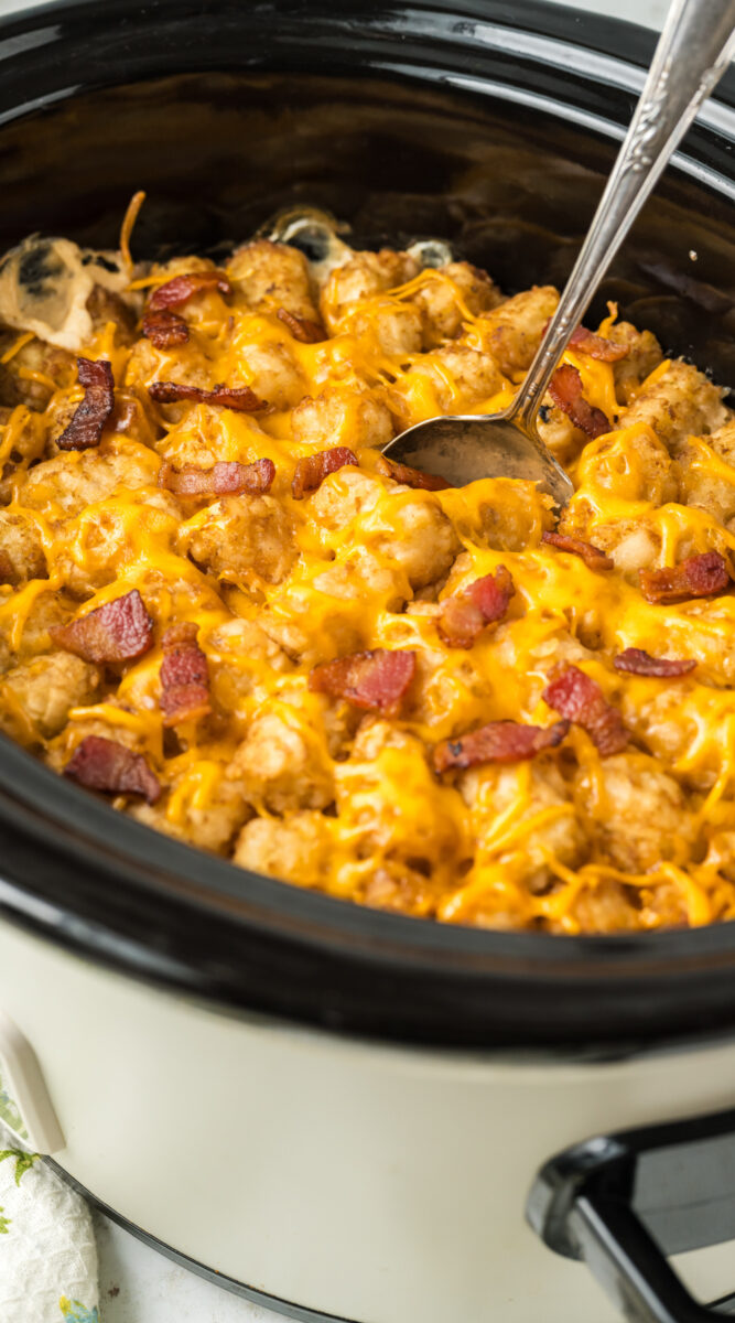 Long image of tater tot casserole with a spoon in it.
