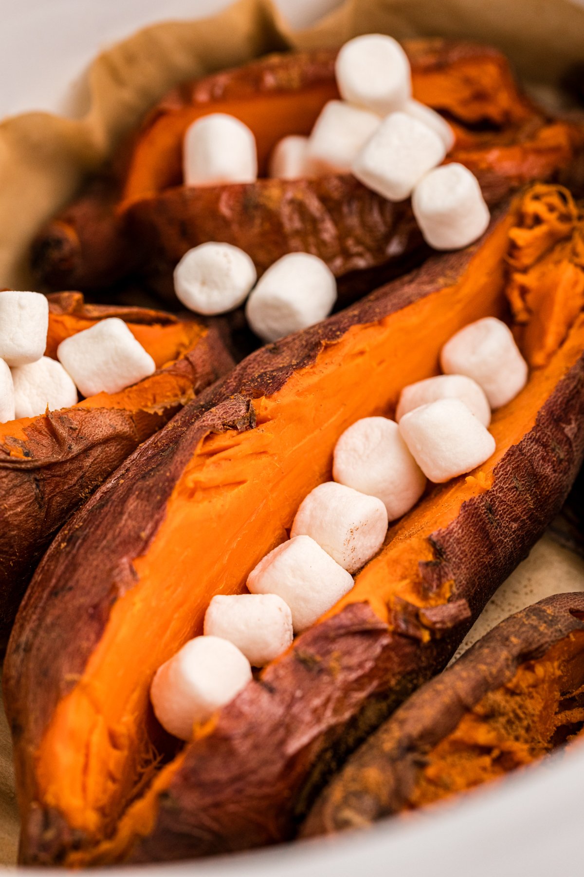 baked sweet potatoes in a slow cooker with marshmallows on top.