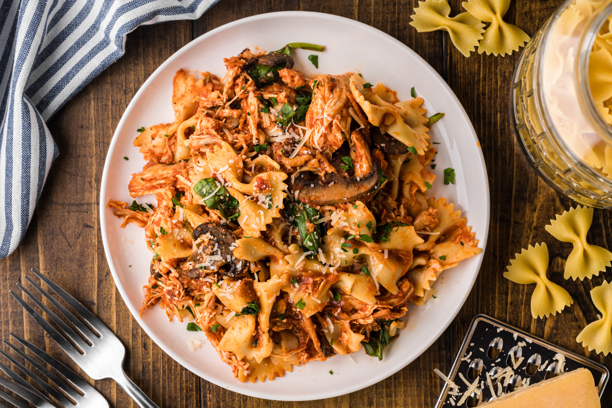 overhead shot of serving of slow cooker chicken bacon pasta on a white plate.