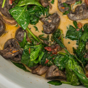 close-up of creamy tuscan mushrooms after cooking in a crockpot.