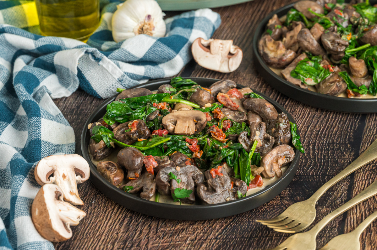 creamy tuscan mushrooms in a black serving dish.