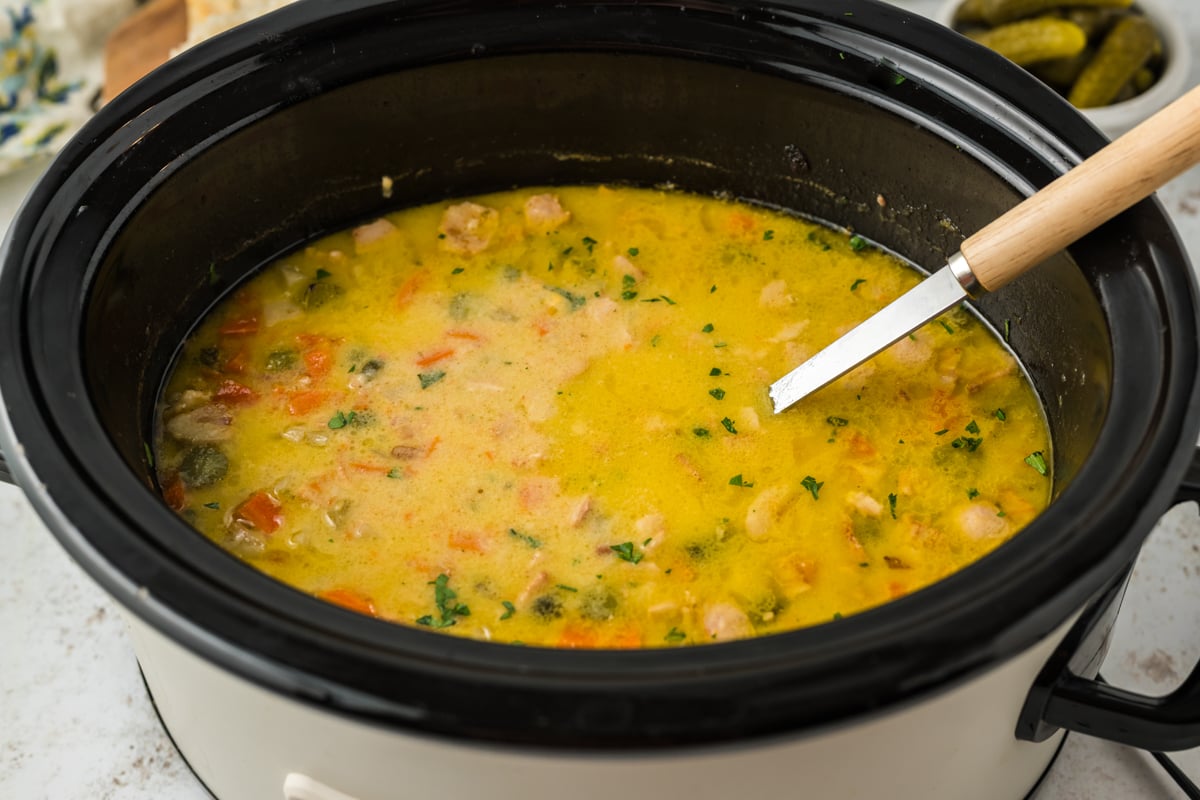 cooked pickle soup in a black crockpot.