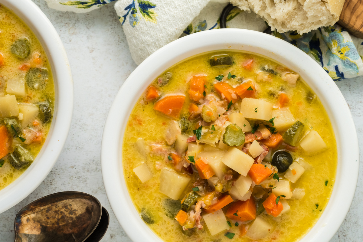 white bowl with dill pickle soup in it.