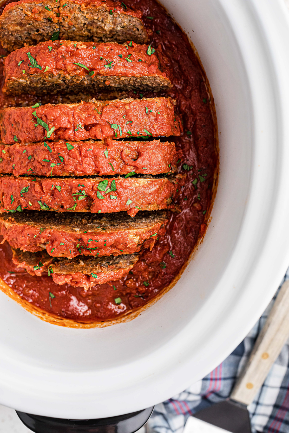 overhead of sliced Italian meatloaf in a slow cooker.