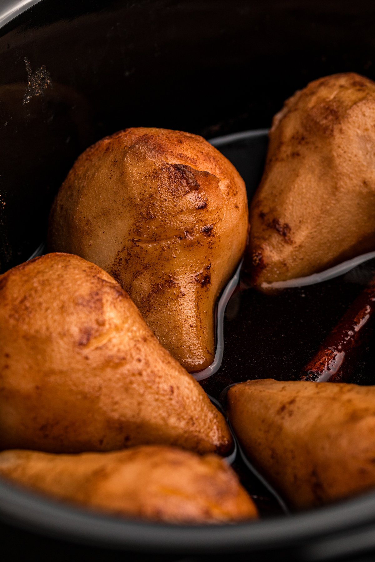 close-up of poached pears in a slow cooker.