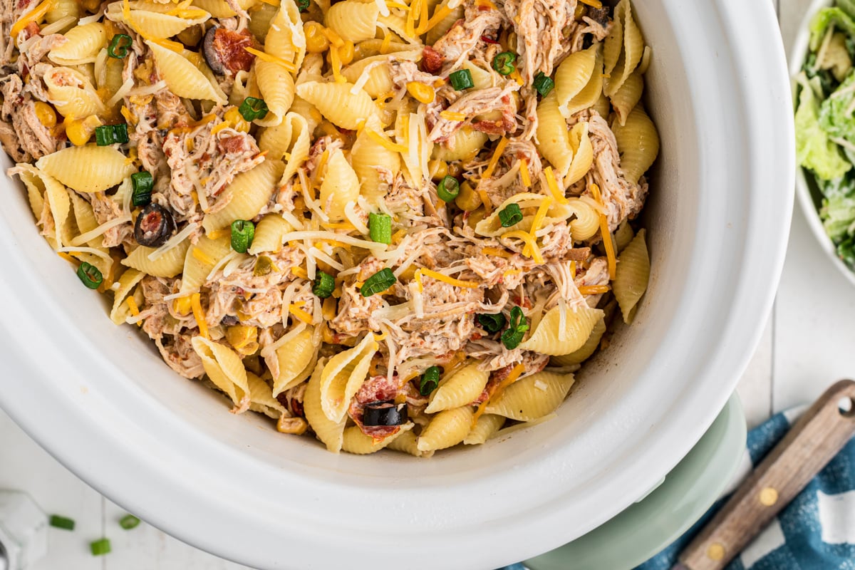 overhead close-up of southwestern cheesy chicken pasta in a slow cooker.