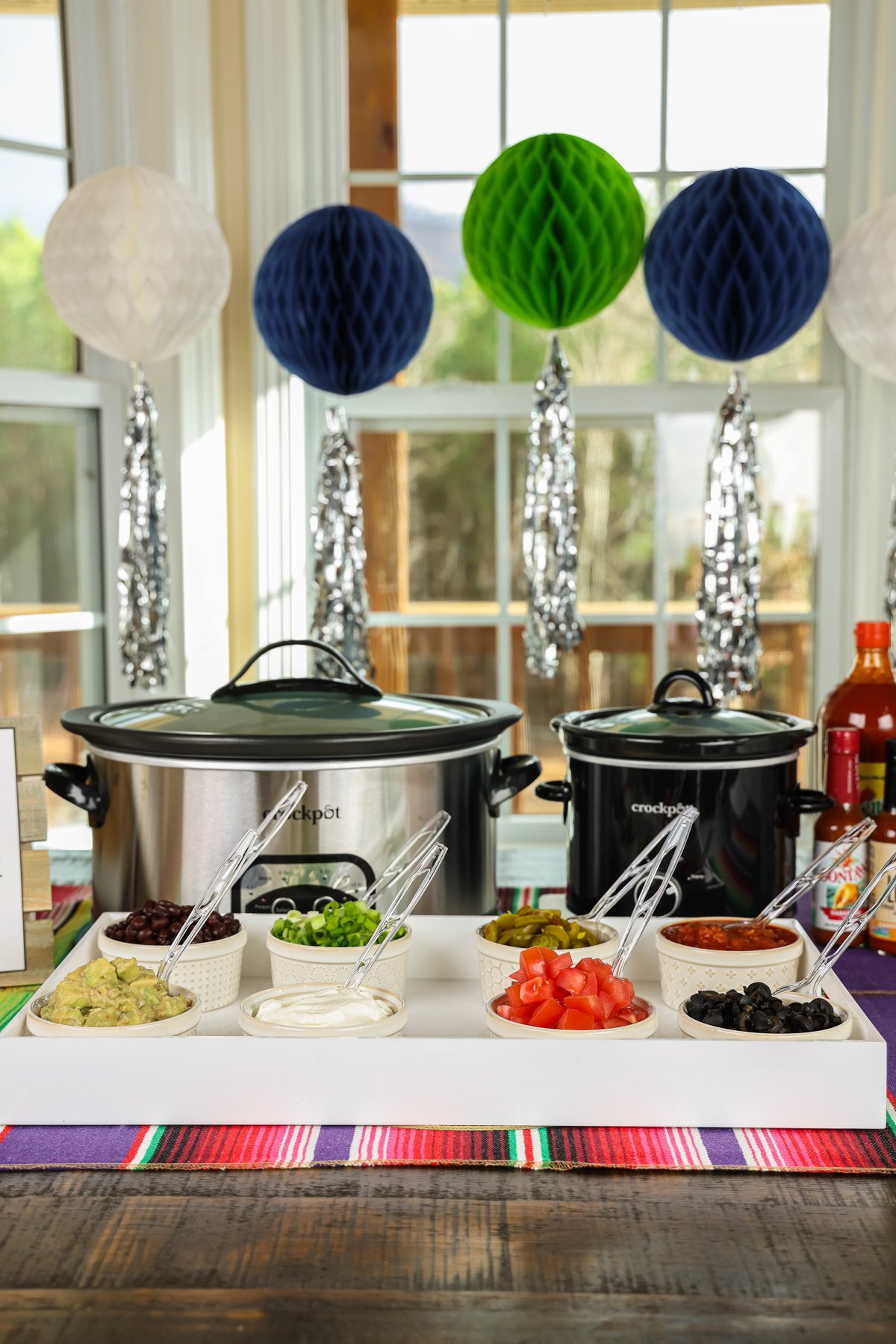 Nacho bar set up with crockpots and toppings.