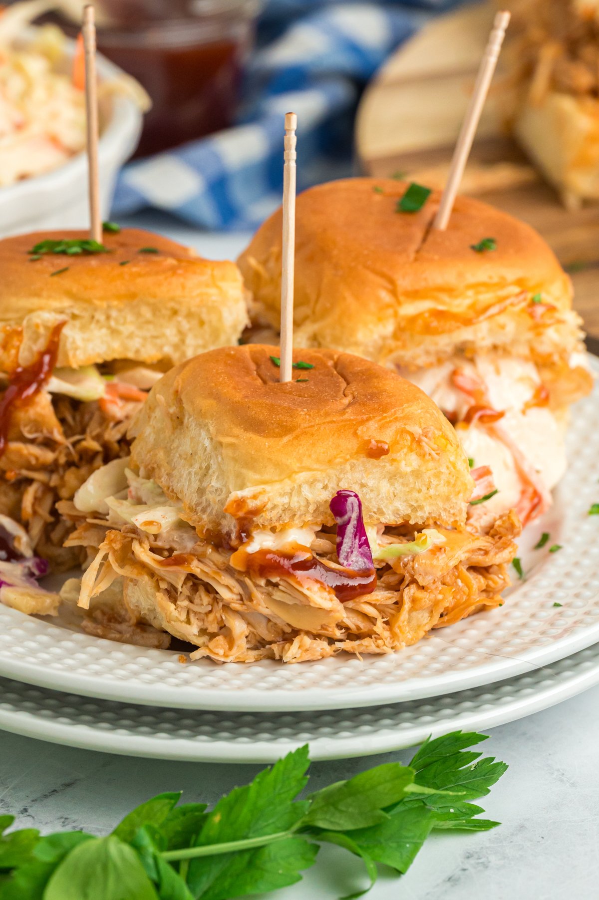 slow cooker bbq chicken sliders on two plates.