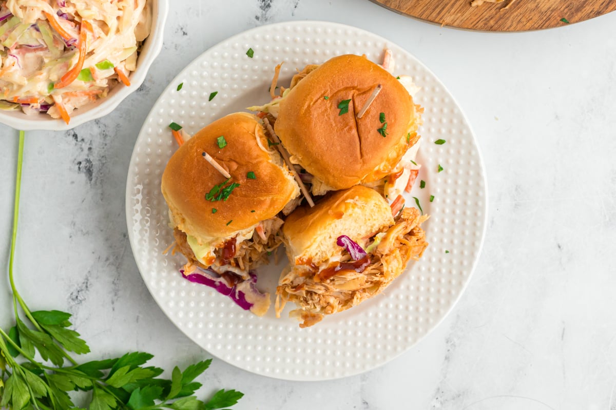 overhead shot of slow cooker bbq chicken sliders on a plate.