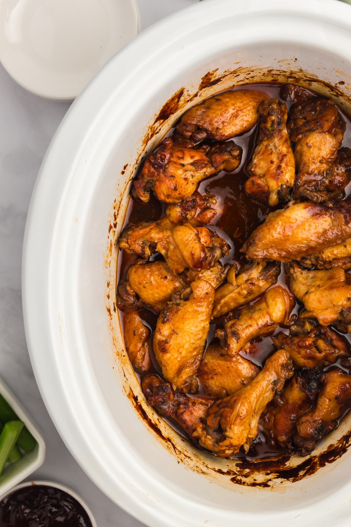 overhead of bbq chicken wings in a slow cooker.