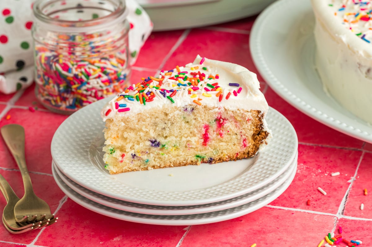 slice of slow cooker birthday cake on a stack of plates.