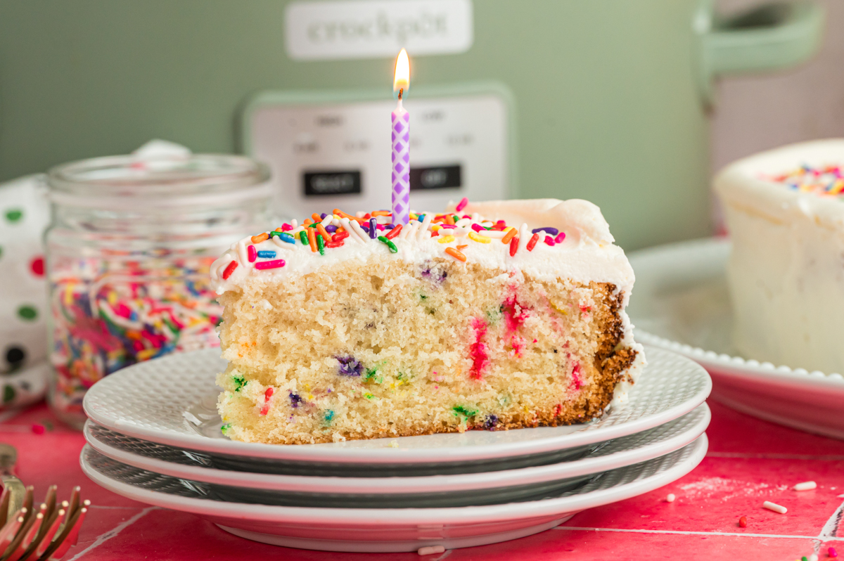 slice of slow cooker birthday cake with a candle.
