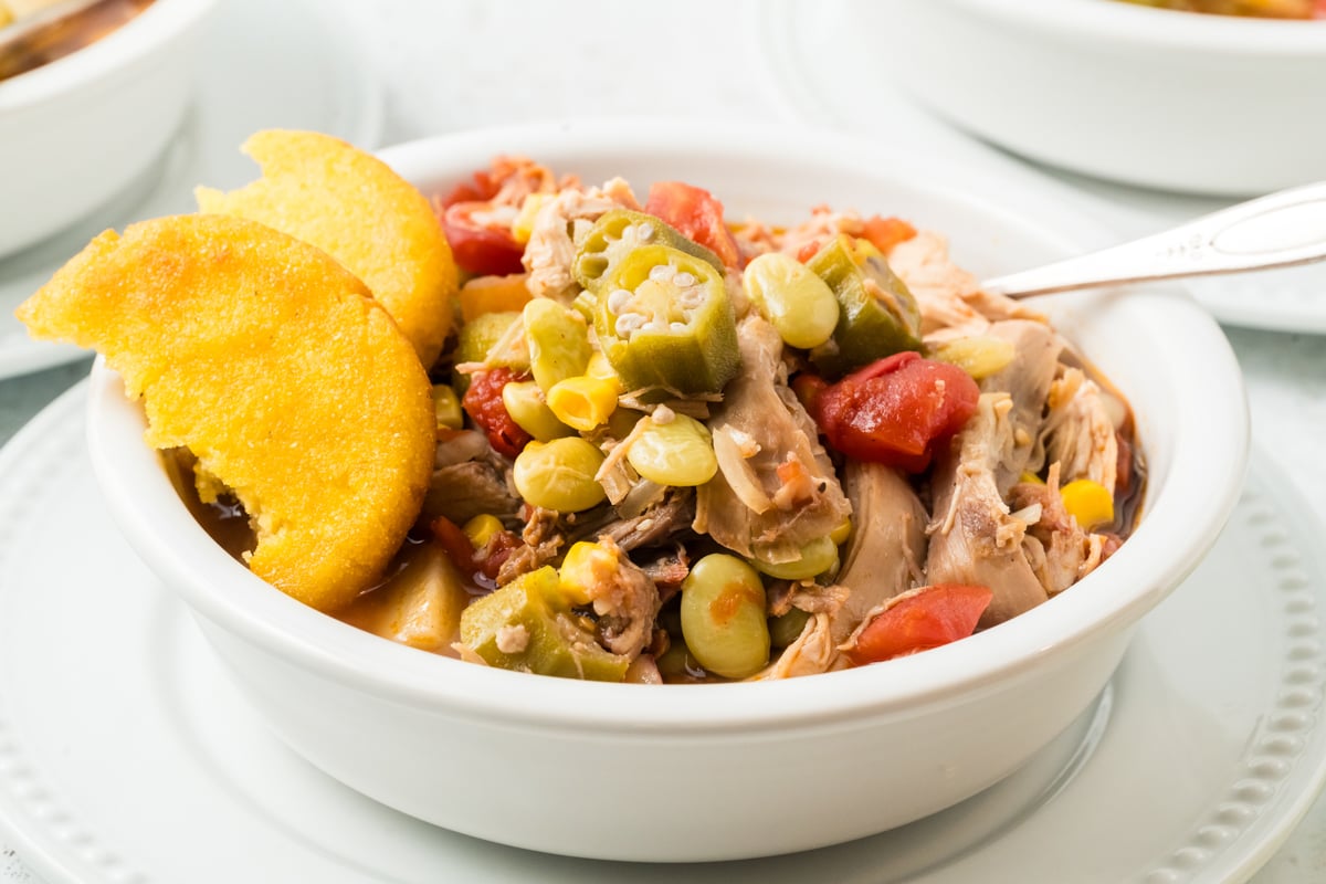 close-up of serving of slow cooker Brunswick stew in a white bowl.