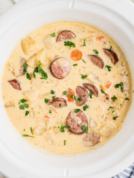 overhead of cheesy kielbasa soup in a slow cooker.