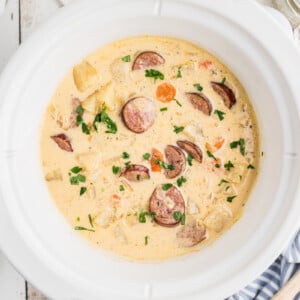 overhead of cheesy kielbasa soup in a slow cooker.