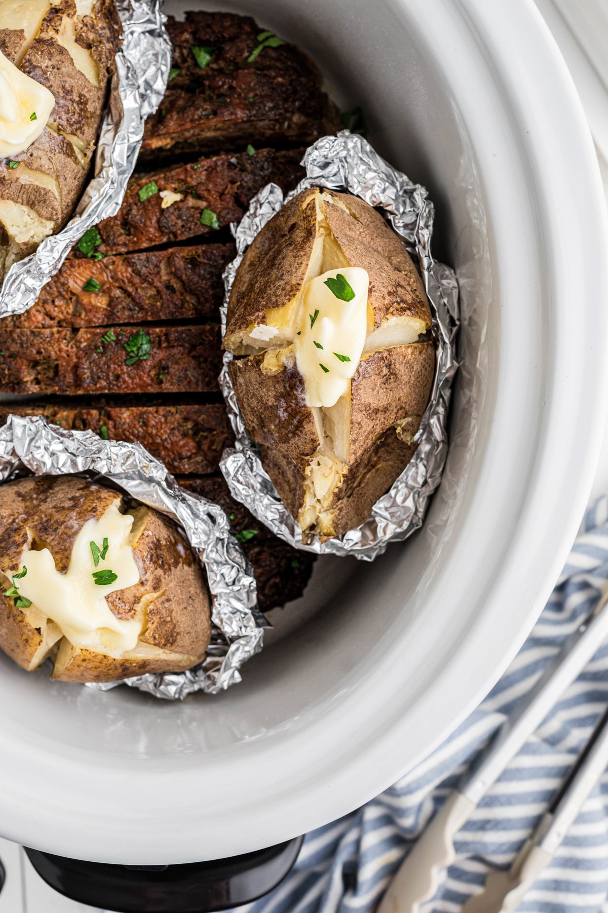 meatloaf and baked potatoes in a slow cooker.