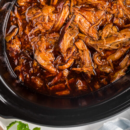 overhead of root beer pulled pork in a slow cooker.