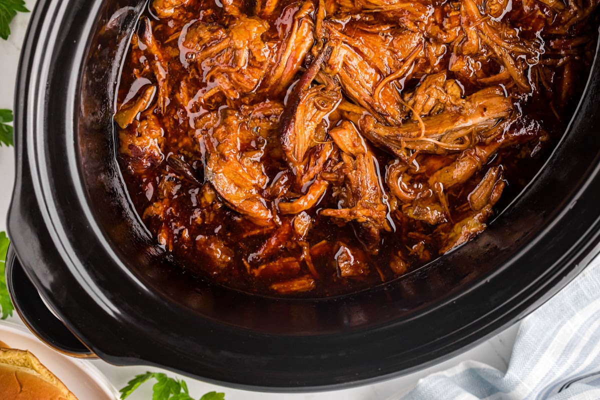 overhead of root beer pulled pork in a slow cooker.