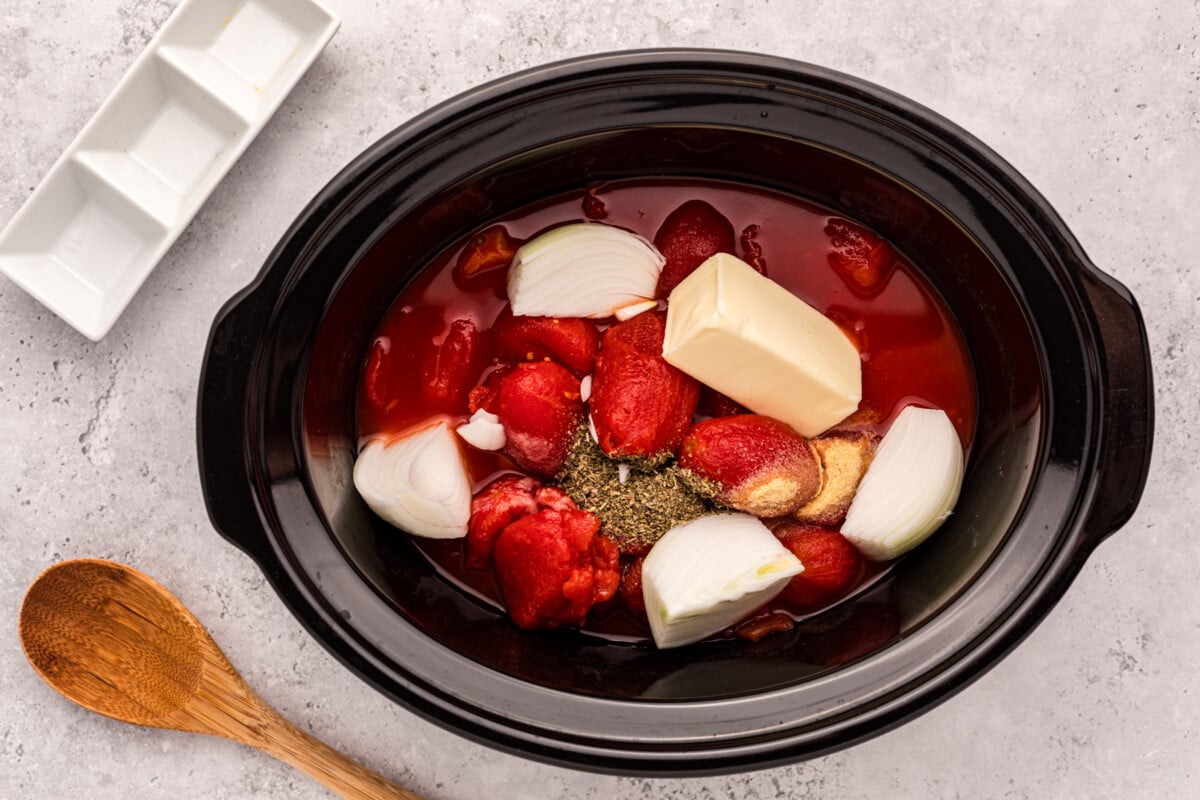 tomatoes, seasonings, onions and butter in a slow cooker.