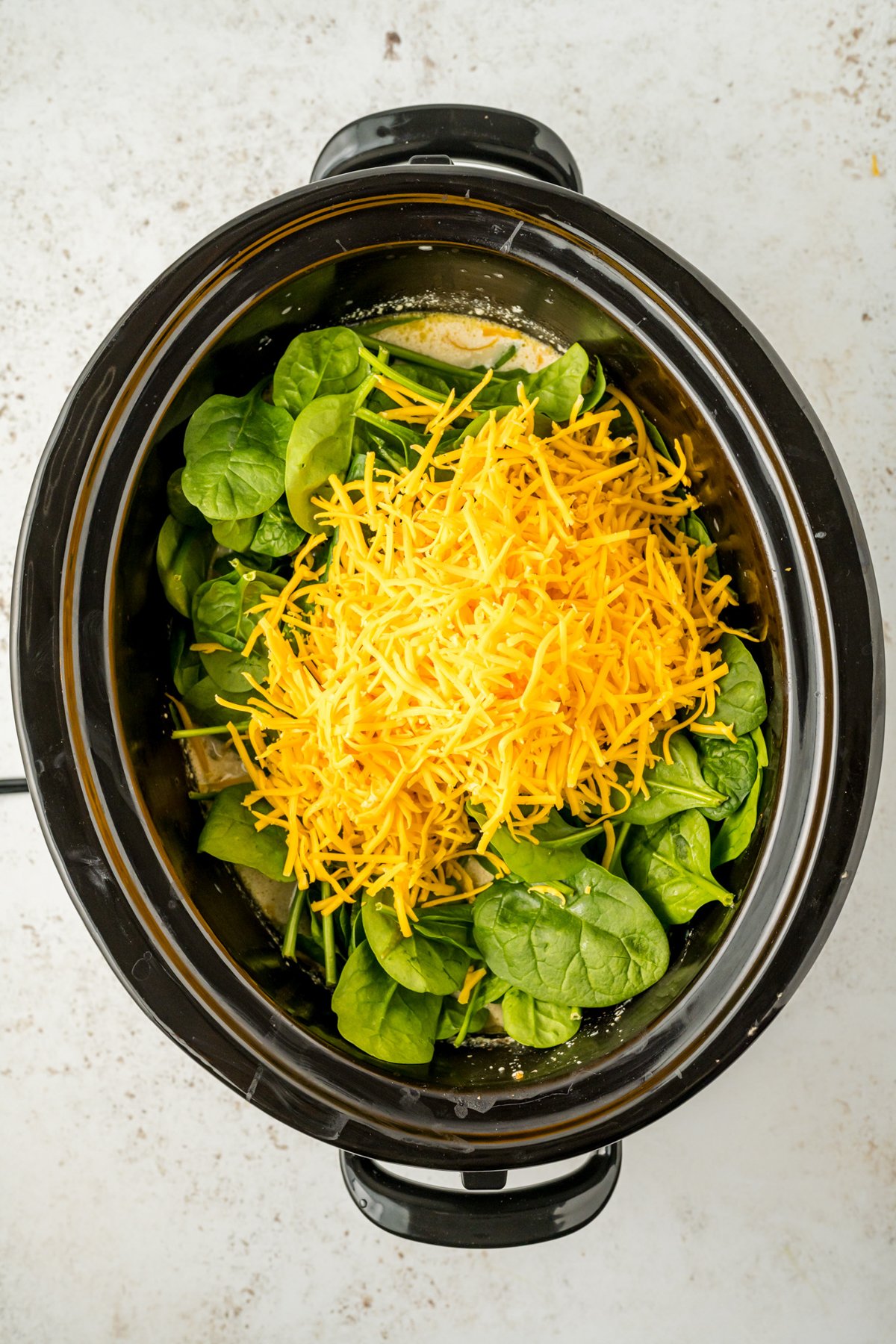 spinach and cheese added to the slow cooker.