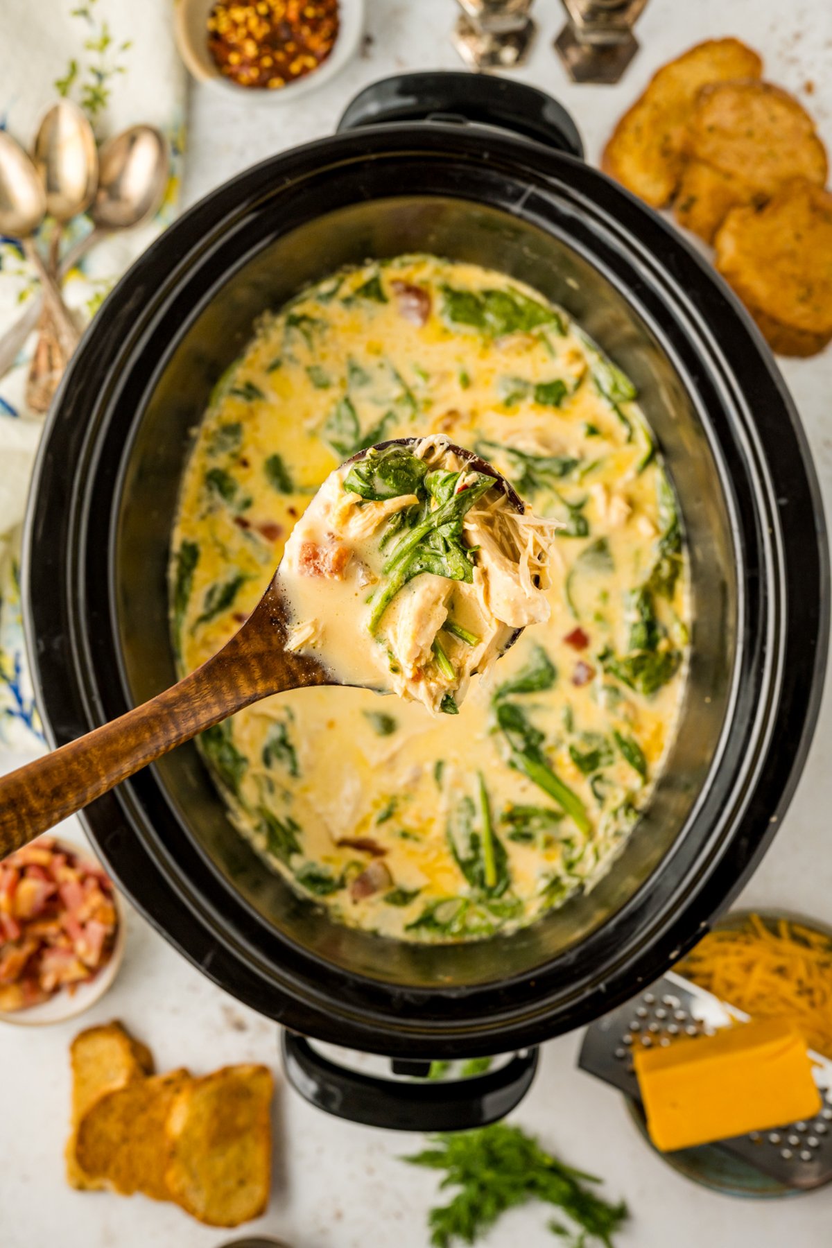 scooping crack chicken soup out of a slow cooker.