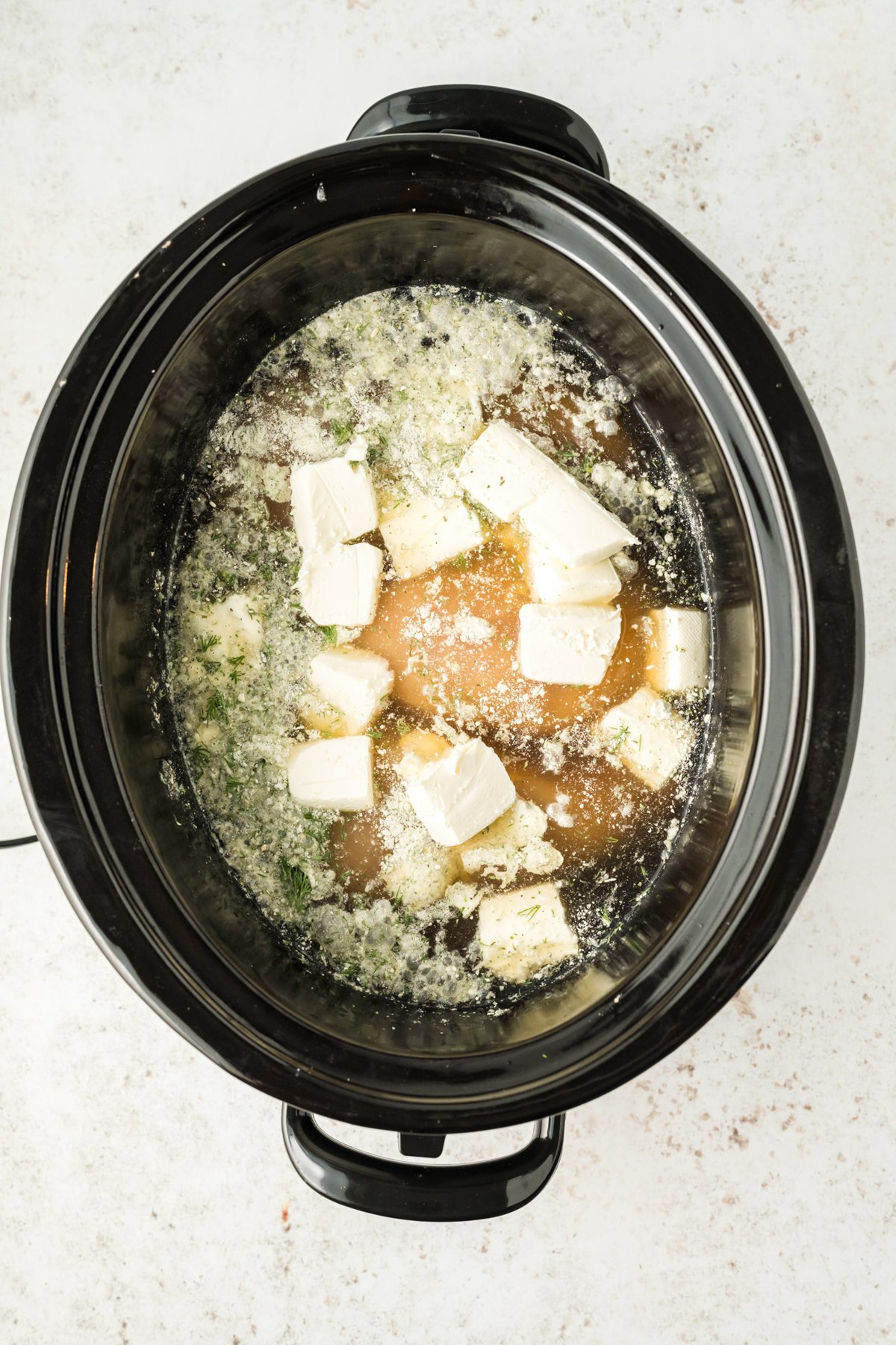 chicken, broth and cream cheese in a slow cooker.