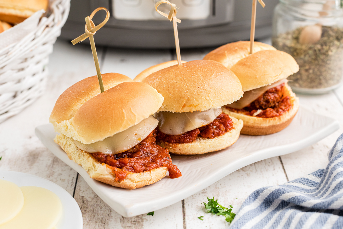three slow cooker meatball sliders on a serving tray.
