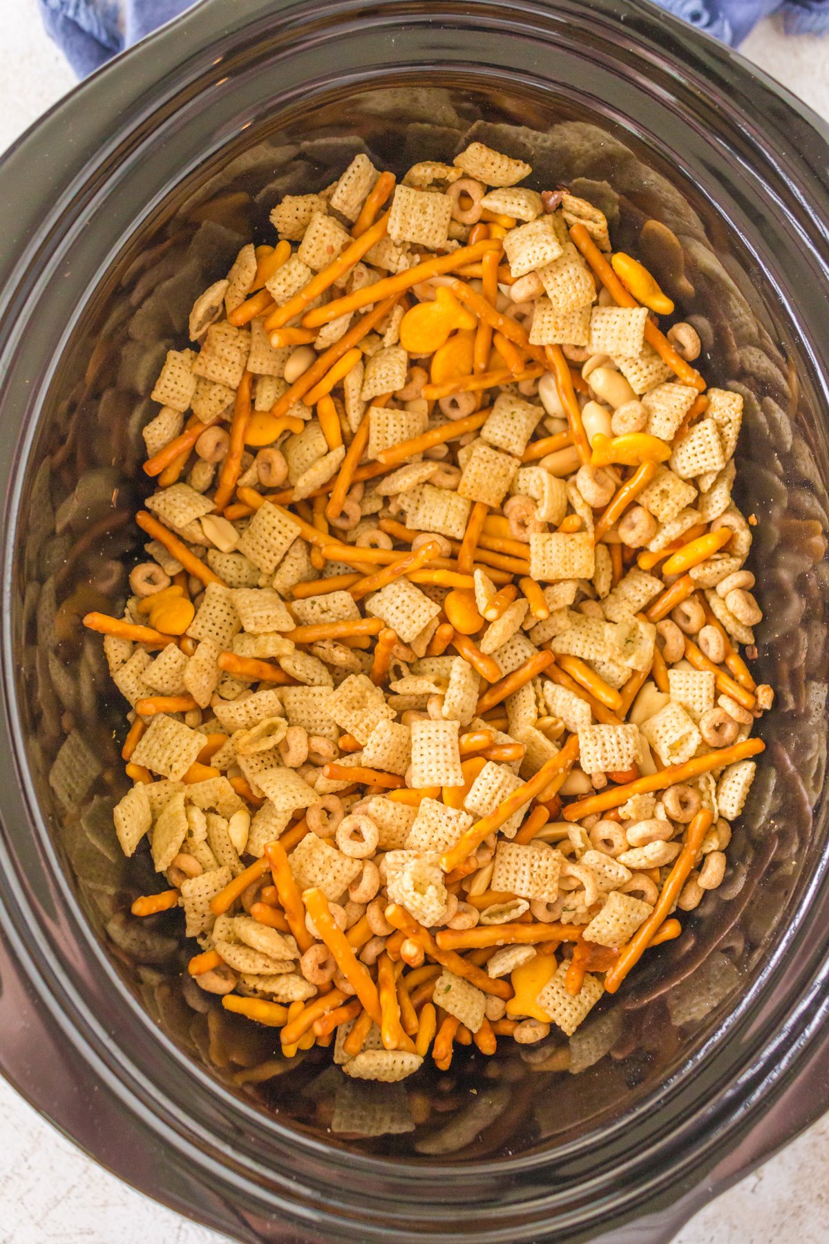 overhead shot of ranch chex mix in a slow cooker.