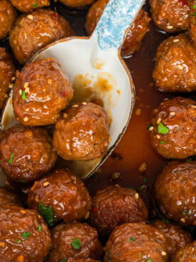 close up of honey garlic meatballs on a spoon.