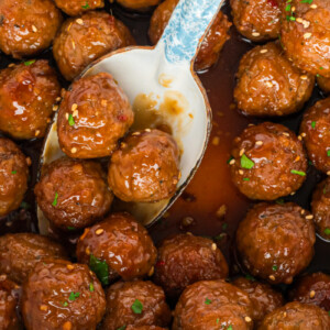 close up of honey garlic meatballs on a spoon.