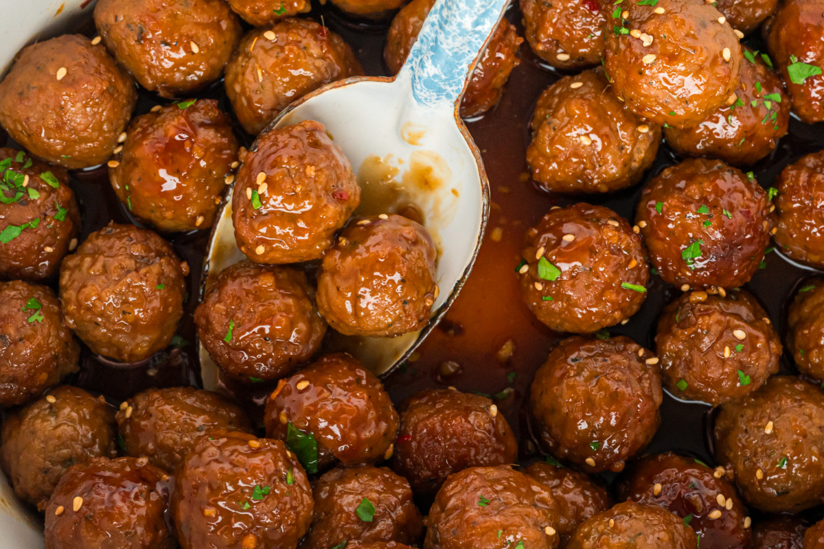 close up of honey garlic meatballs on a spoon.