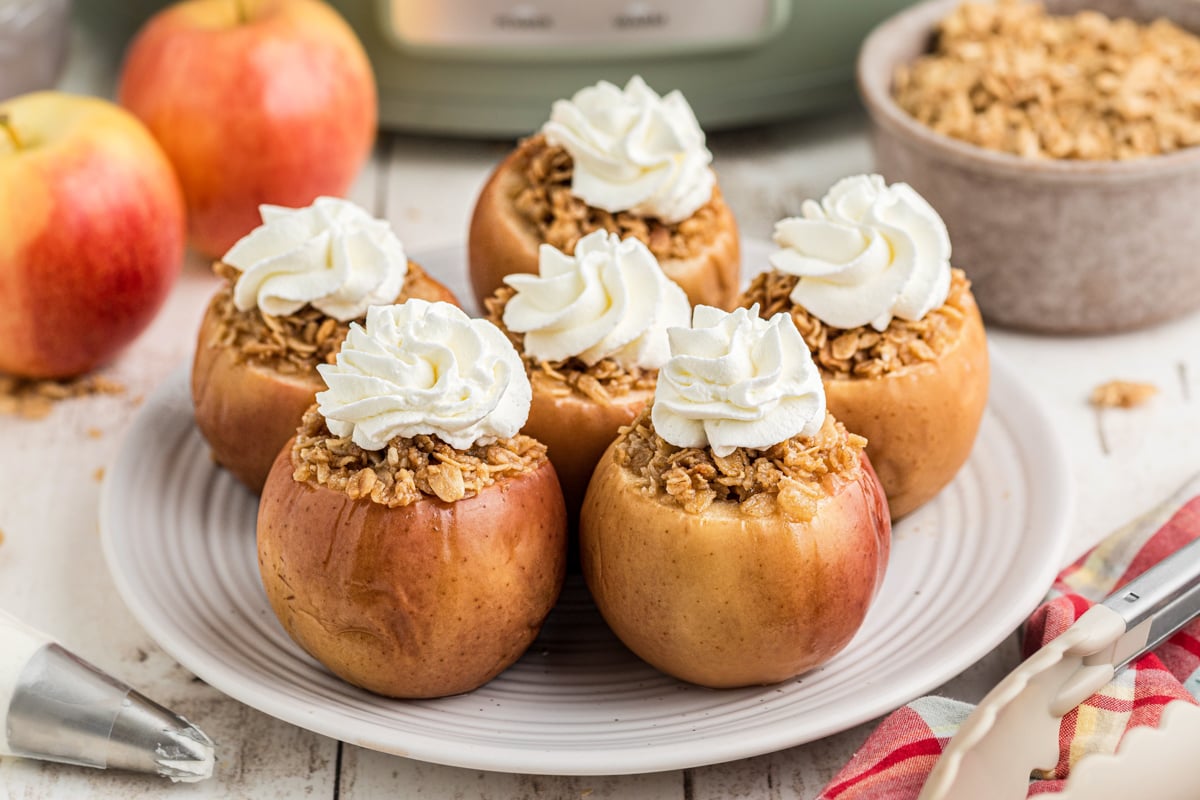 slow cooker baked apples with whipped cream on top.