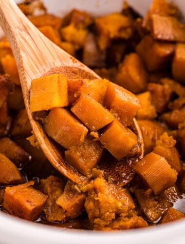 scooping butternut squash out of a slow cooker.