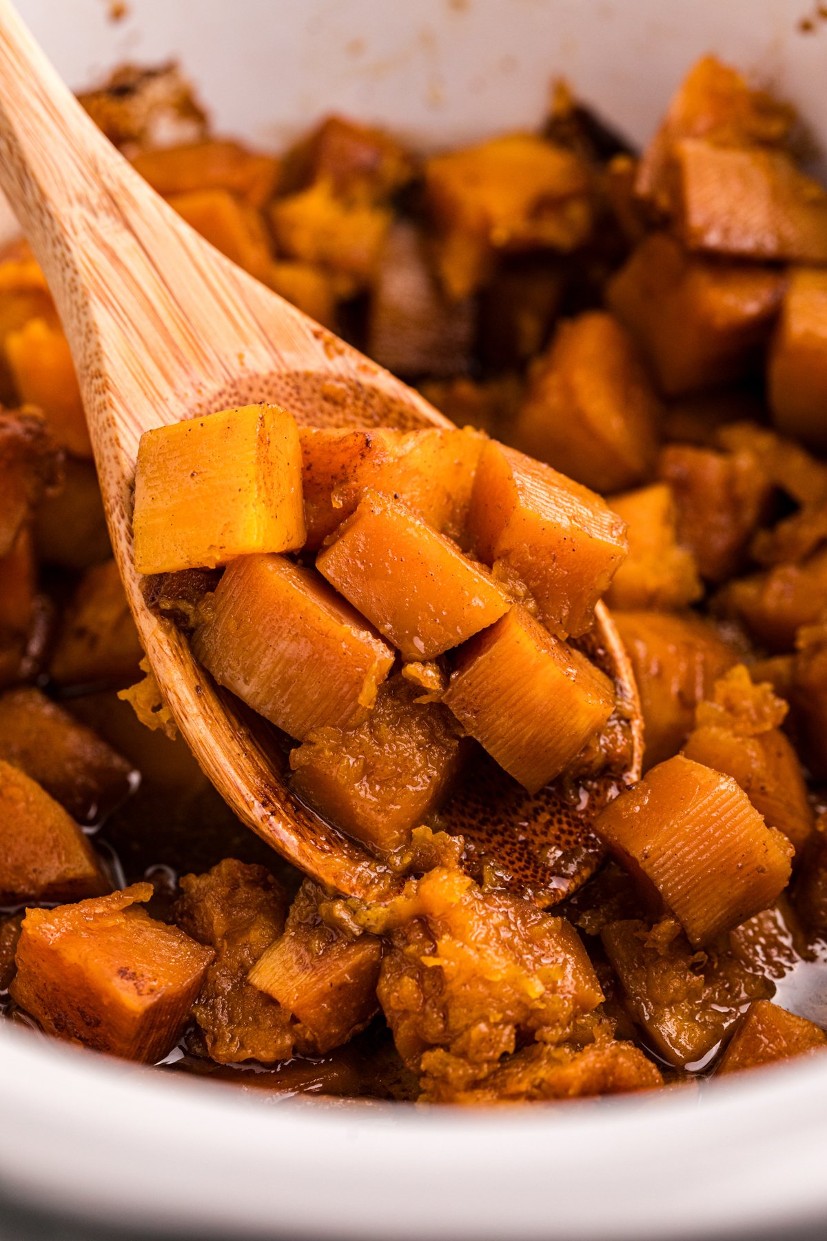 scooping butternut squash out of a slow cooker.