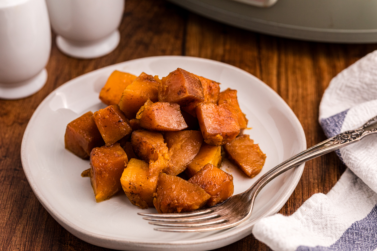 serving of slow cooker butternut squash on a plate with a fork.
