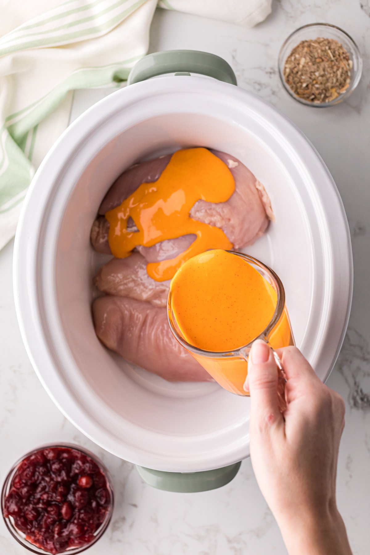 French dressing being poured over chicken.