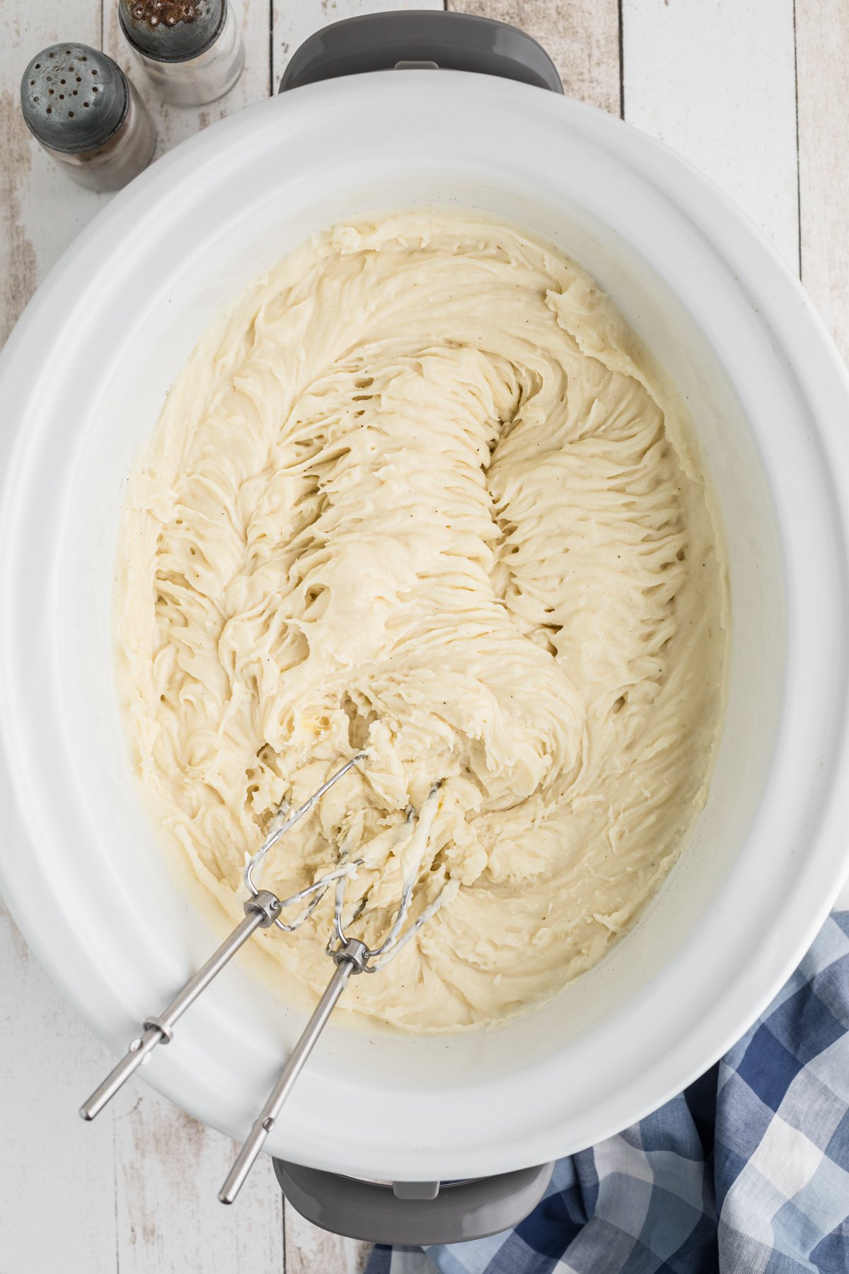 mashed potatoes being blended in a slow cooker.