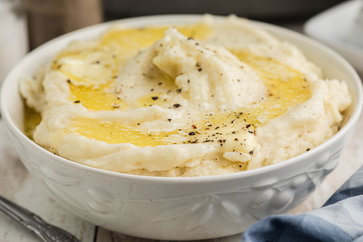 close-up of slow cooker mashed potatoes in a white bowl.