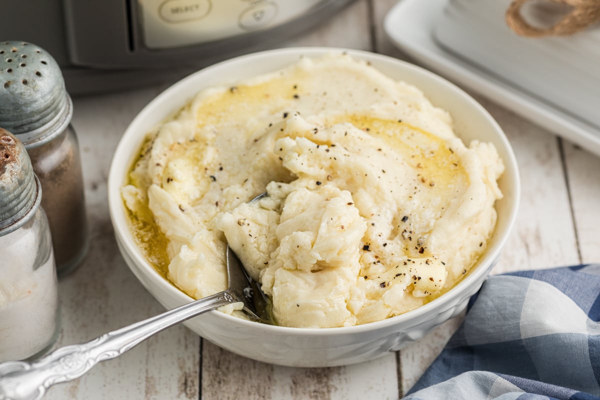 slow cooker mashed potatoes in a bowl with a spoon.