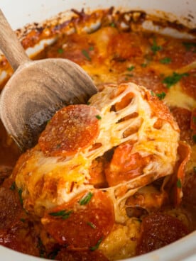 spoon scooping out crockpot pizza chicken.